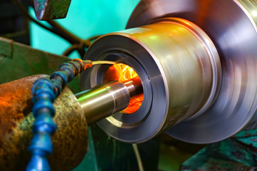 Production of parts in the metalworking industry, finishing on an internal steel surface grinding machine with flying sparks.