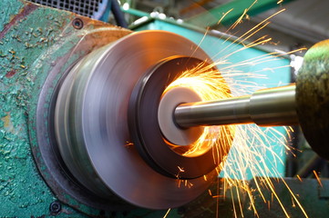 Production of parts in the metalworking industry, finishing on an internal steel surface grinding machine with flying sparks.