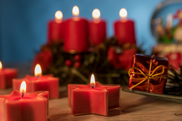Obraz na płótnie Canvas Christmas ball and burning candles on blue background Christmas and winter decoration
