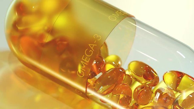 Big capsule filled with yellow, gel omega 3, fish oil or vitamin D pills.