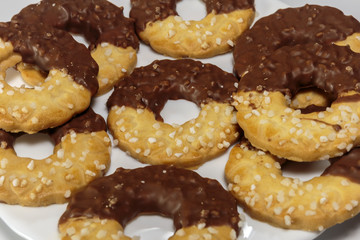 Sweet delicious ring-shaped chocolate chip cookies on a dish. White background.