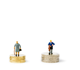 Small figurines and coins. Gender pay gap.