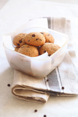 Peanut Butter Chocolate Chip Cookies in a little box, on a kitchen towel.