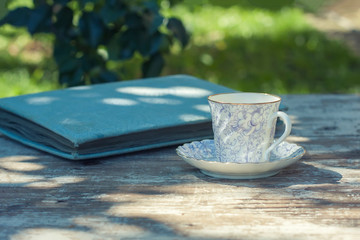 Porcelain cup of tea on a wooden table in the garden. Summer party