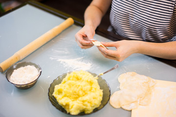 woman cooks delicious dumplings in the kitchen. Close up