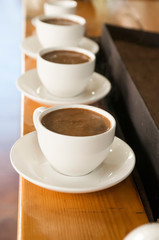 Obraz premium row of white cups with coffee with