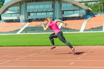 Obraz premium A young girl in the stadium runs.