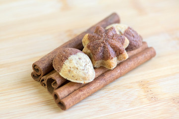 Cinnamon sandbakelse christmas cookies, two colors, cocoa dark brown and vanilla light golden brown, cinnamon raw bark spice