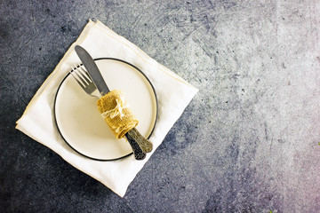 White plate and cutlery on stone table top view. Table setting.