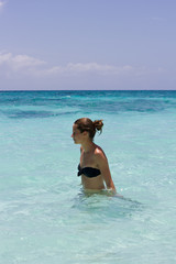 Junge sportliche Frau steht im Wasser in der Karibik