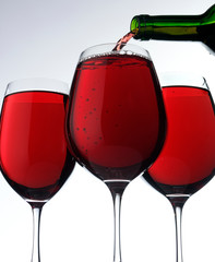 POURING RED WINE INTO THREE GLASSES