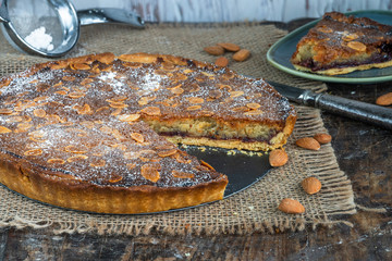 Traditional home baked bakewell tart on rustic wooden board