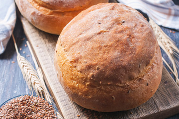 Homemade  freshly baked  bread with flax seeds  on dark wooden b