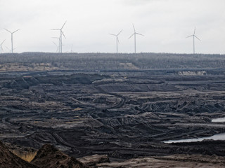 coal mine aerial view with wind turbines at the horizon.