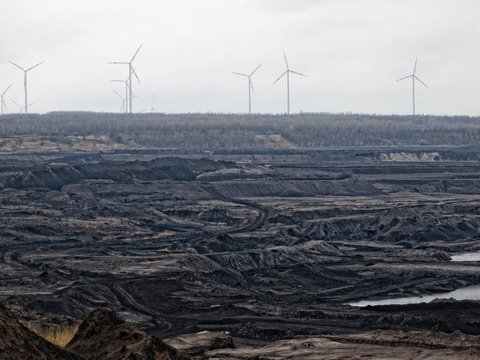coal mine aerial view with wind turbines at the horizon.