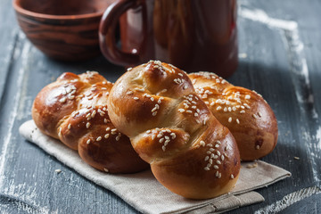  wheat buns with sesame seeds on a dark wooden background