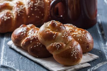  wheat buns with sesame seeds on a dark wooden background