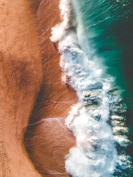 Aerial view of waves crashing along the shore