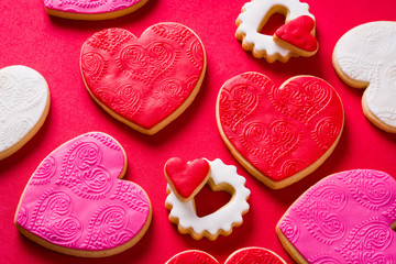 Heart-shaped cookies for Valentine's Day on red background. Top view.