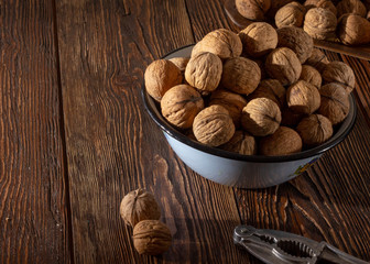 Walnuts in a blue plate on a wooden table