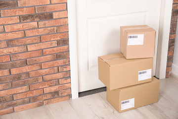 Cardboard parcel boxes on floor near apartment entrance. Mockup for design