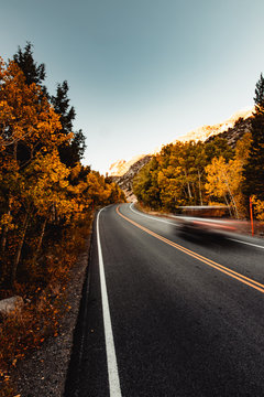 Car driving down a road in autumn
