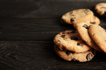 Tasty chocolate chip cookies on wooden table. Space for text