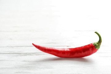Fresh red chili pepper on wooden table. Space for text
