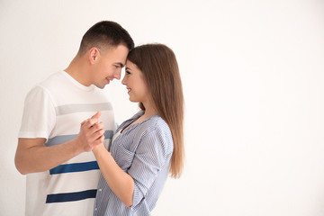 Young couple dancing together against white background