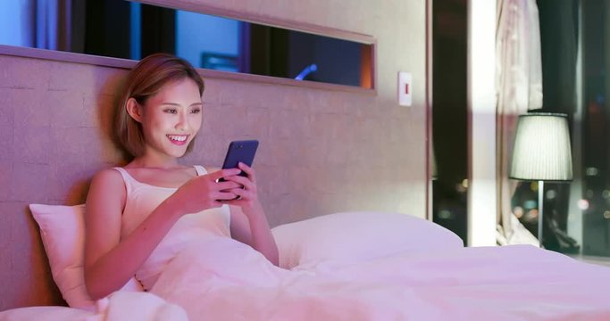 woman use phone on bed