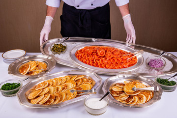 Pancakes, are served with red fish and other snack