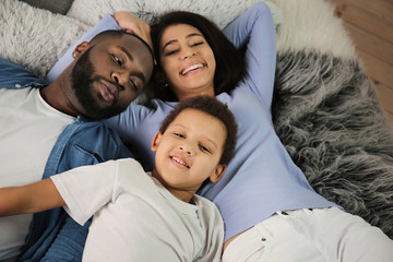 Cute African-American boy with parents at home