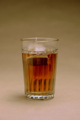 Glass with black tea on a brown background