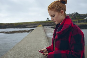 Woman using mobile phone in the beach