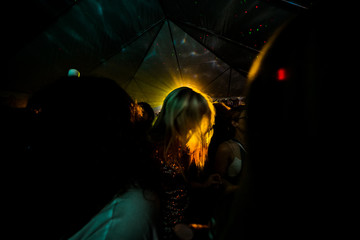 People inside a dark room with only a light shining from a lamp
