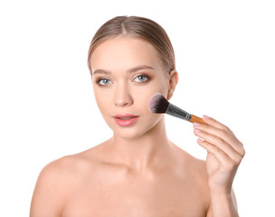 Portrait of beautiful young woman with makeup brush on white background
