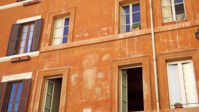 Beautiful european urban architecture. Exterior of old residential building in center of Rome, Italy. Colorful facade of roman house. Camera moving sideways in slow motion