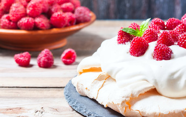 Homemade cake Pavlova with whipped cream and fresh raspberry.