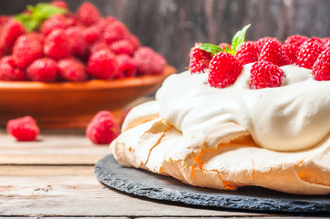 Homemade cake Pavlova with whipped cream and fresh raspberry.