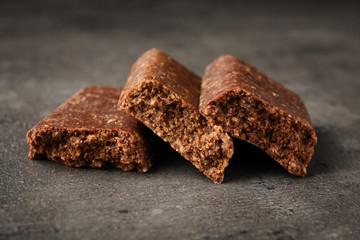 Pieces of tasty protein bar on grey table