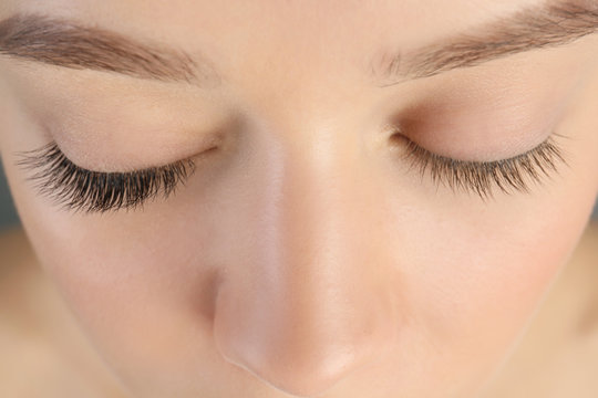 Young woman with beautiful eyelashes, closeup. Before and after extension procedure