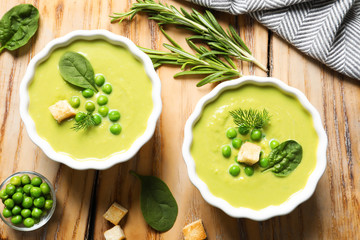 Fresh vegetable detox soup made of green peas and spinach with croutons served on table
