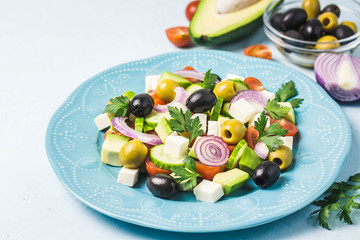 Avocado olives greek salad on blue plate.Selective focus, space for text.