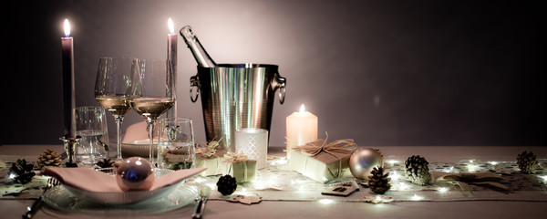 Fototapeta na wymiar christmas eve party table with white wine glass and glitter season's greeting decoration horizontal header