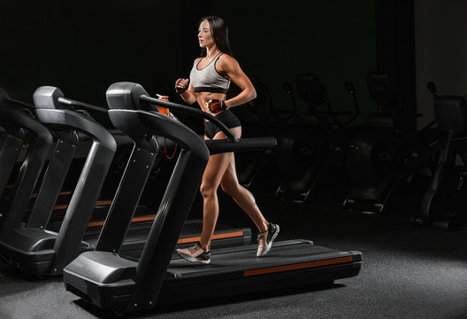 Pretty Latin young women working out in an elliptical trainer in a gym