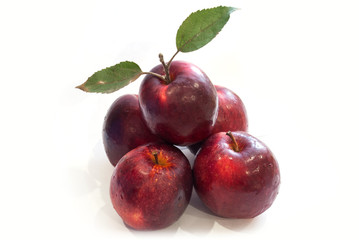 Fresh red apples with leaves isolated on white background