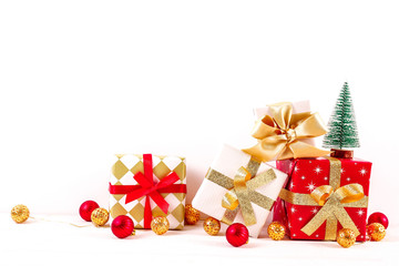 Minimalistic festive composition with small christmas tree, wrapped present and colorful matte balls. Fancy beautiful decoration for christmas pine tree. Background, copy space, close up, front view.