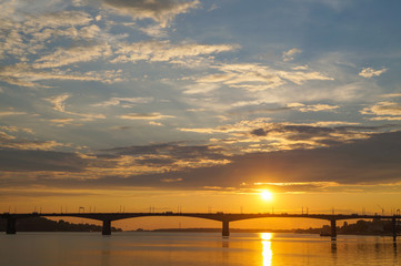 Beautiful orange sunset over the bridge on the Volga river in Kostroma