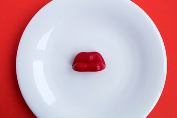 Red lips on the white plate .Top view.Copy space.