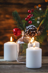 Christmas decorations, burning candles, spruce on a wooden background. New Year's concept. Postcard